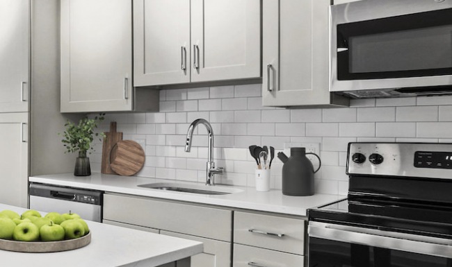 Kitchen Kitchen with stylish backsplash, white cabinetry and stainless steel appliances