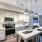 Model kitchen at our apartments for rent in Fairfax, VA, featuring stainless steel appliances and wood grain floor paneling.